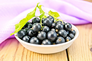 Image showing Black currants in bowl with napkin on board