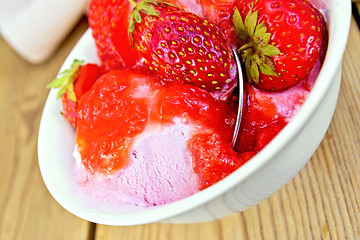Image showing Ice cream strawberry in bowl with spoon on board