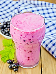 Image showing Milkshake with black currant and leaves on board