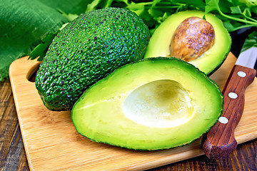 Image showing Avocado with knife on board