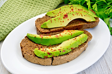 Image showing Sandwich with avocado and pepper in bowl on light board