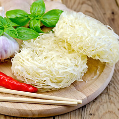 Image showing Noodles rice twisted with spices and basil on board