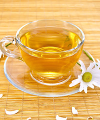 Image showing Herbal tea with camomiles on bamboo napkin