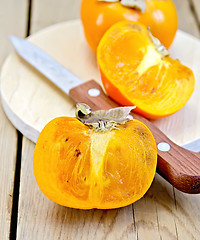 Image showing Persimmon with knife on board