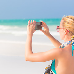 Image showing Woman taking photo on the beach.