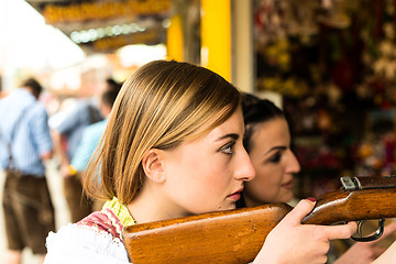 Image showing Two attractive girls playing shooting games at German funfair