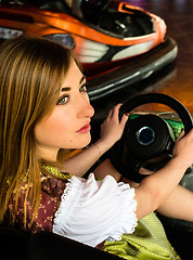 Image showing Beautiful girl in an electric bumper car in amusement park