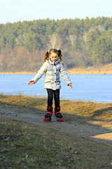 Image showing young girl goes in roller skates on the ground