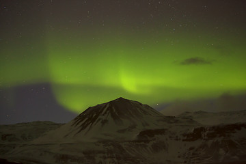 Image showing Northern lights with snowy mountains in the foreground