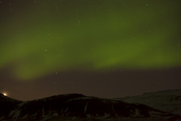 Image showing Northern lights with snowy mountains in the foreground