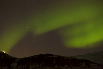 Image showing Northern lights with snowy mountains in the foreground