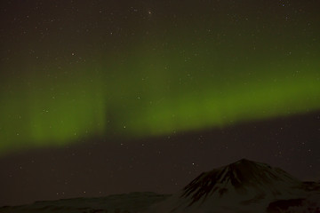 Image showing Northern lights with snowy mountains in the foreground