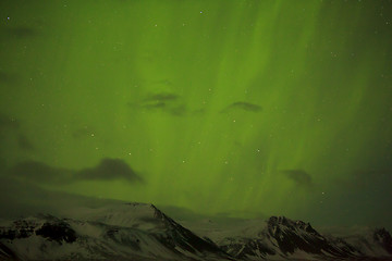 Image showing Northern lights with snowy mountains in the foreground