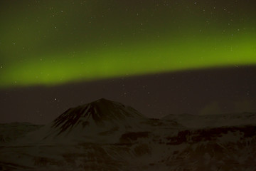 Image showing Northern lights with snowy mountains in the foreground