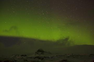 Image showing Northern lights with snowy mountains in the foreground