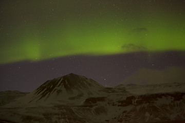 Image showing Northern lights with snowy mountains in the foreground