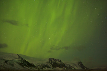 Image showing Northern lights with snowy mountains in the foreground