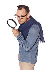 Image showing Serious man looking through magnifying glass