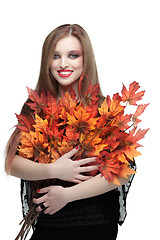 Image showing Smiling young woman with autumn maple leaves 