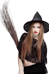 Image showing Showy young woman in witch costume with a broom