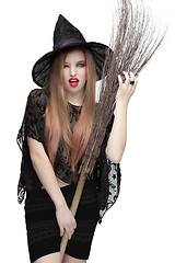 Image showing Woman winking eye in witch costume with a broom 