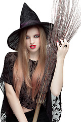 Image showing Portrait of young woman in witch costume with a broom