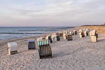 Image showing Beach chairs with dunes at sunset