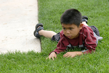 Image showing Boy resting on the grass