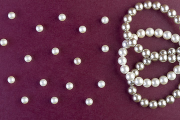 Image showing Silver and White pearls necklace on dark red  