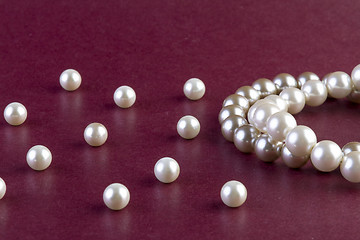 Image showing Silver and White pearls necklace on dark red 