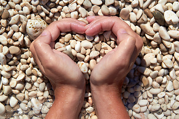 Image showing Hands in the form of heart with pebbles inside