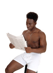 Image showing Black man in underwear reading.