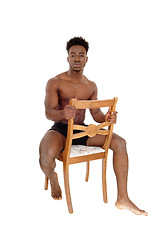 Image showing Black man sitting on chair.