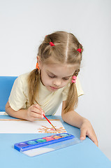 Image showing Six year old girl sitting at the table and draws paints