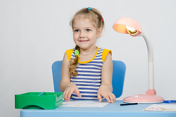 Image showing Four-year girl picks up a picture