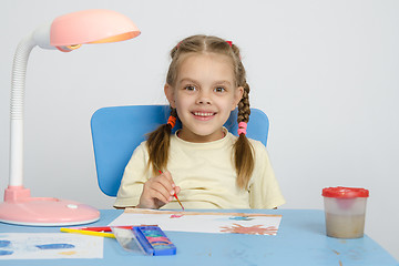 Image showing Six year old girl smiling happily, drawing the table