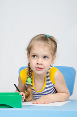 Image showing The girl drawing with pencils at the table looked left