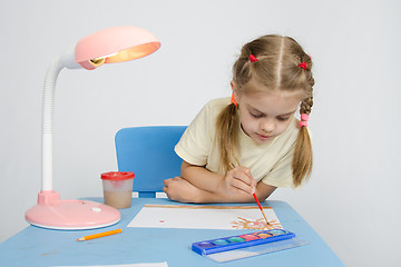 Image showing Girl paints sitting at the table