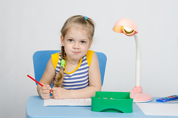 Image showing Four-year girl draws pencils and funny looks in picture