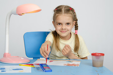 Image showing Six year old girl dunks brush in the paint