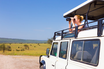 Image showing Woman on safari looking through binoculars.