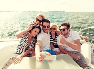 Image showing smiling friends sitting on yacht deck