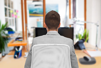 Image showing businessman sitting in office chair from back