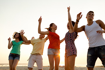 Image showing smiling friends dancing on summer beach