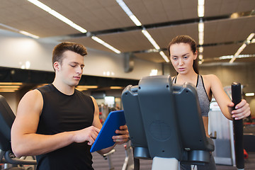 Image showing woman with trainer exercising on stepper in gym