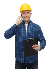 Image showing smiling builder in helmet calling on smartphone