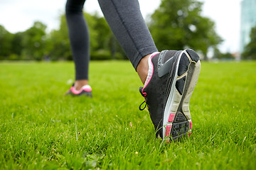 Image showing close up of exercising woman legs on grass in park