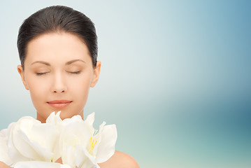 Image showing beautiful woman smelling flowers with closed eyes