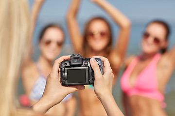 Image showing close up of smiling women photographing on beach