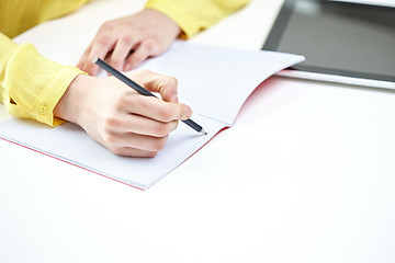 Image showing close up of female hands writing to notebook